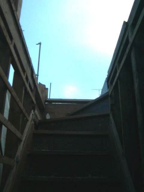 取り壊した家の階段を上ると二階の部屋はなく、空が広がっています