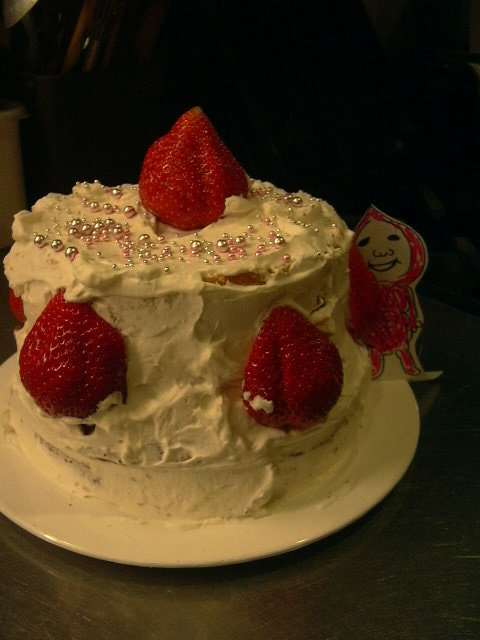 イチゴ頭のこびと野郎が覗いているクリスマスケーキ
