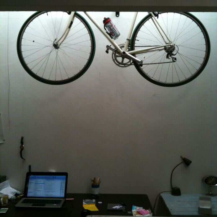 パソコンで仕事する机の上に自転車をフックで収納