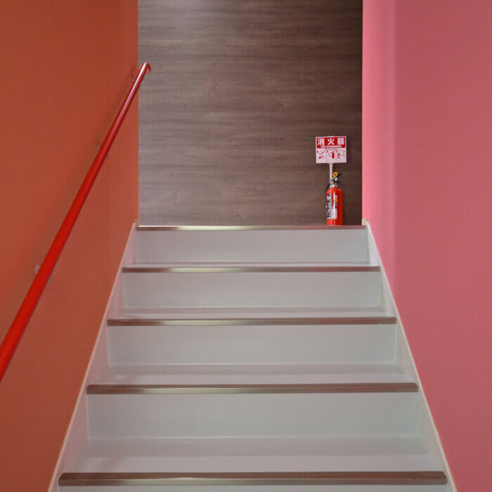 DFビル　内装デザイン　ピンクとオレンジの壁紙の階段