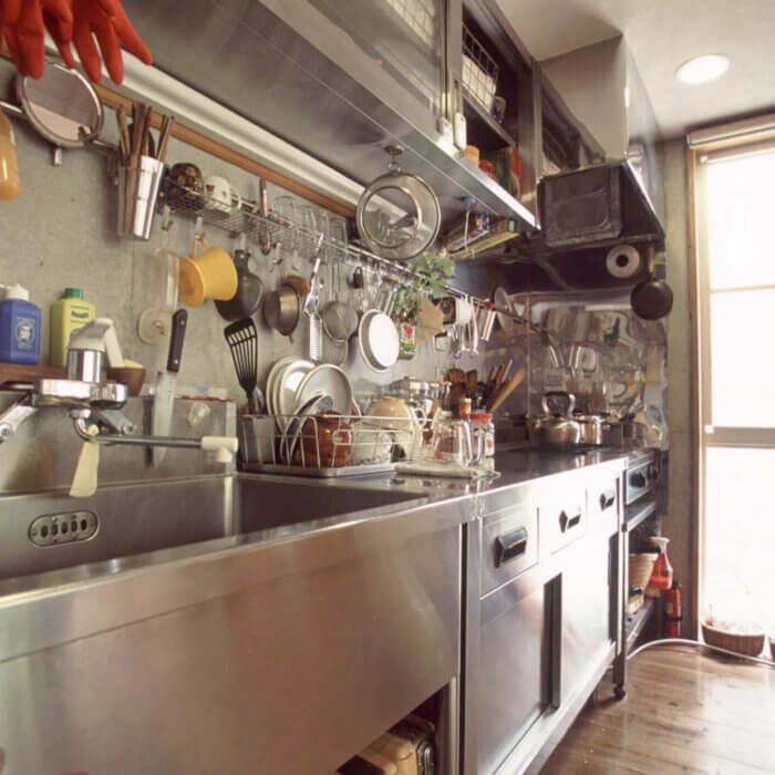 プロ仕様の厨房用品のリサイクル店で集めた調理器具や食器がたくさん置かれたステンレスの調理スペース