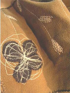 ミシンの縫い目で花が描かれた、茶色の布