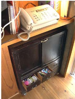 リビングの電話の下に置かれた、元は仏壇だった黒い収納家具