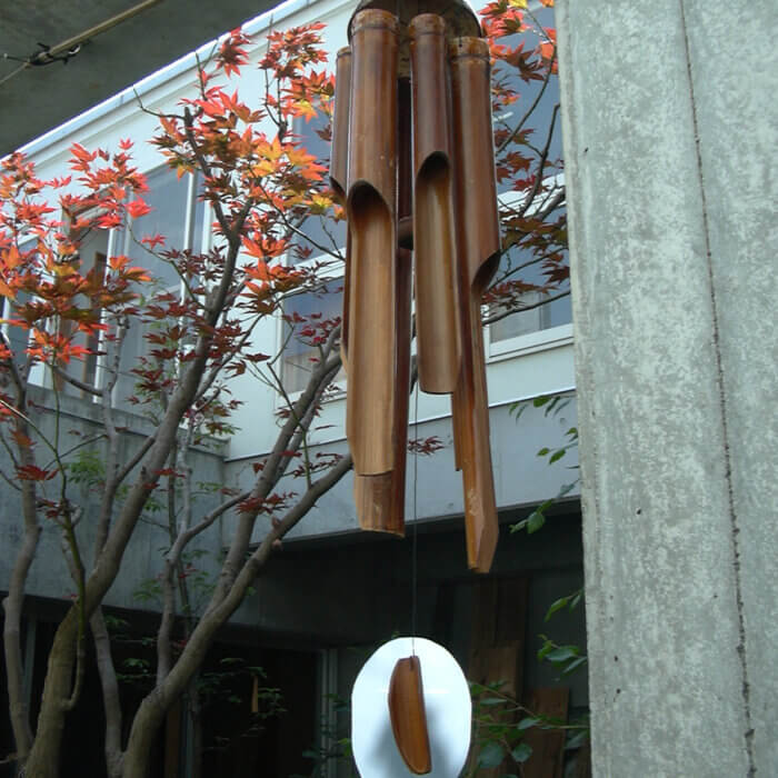 庭に吊るされた、茶色の竹でできた風鈴