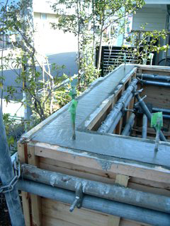 庭に工事中の小屋の木の枠に、コンクリートが流し入れられた状態