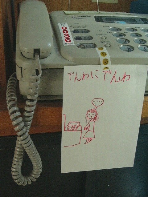 リビングの電話機に貼られた、子どもが書いた「でんわにでんわ」というギャグとイラストが描かれた紙